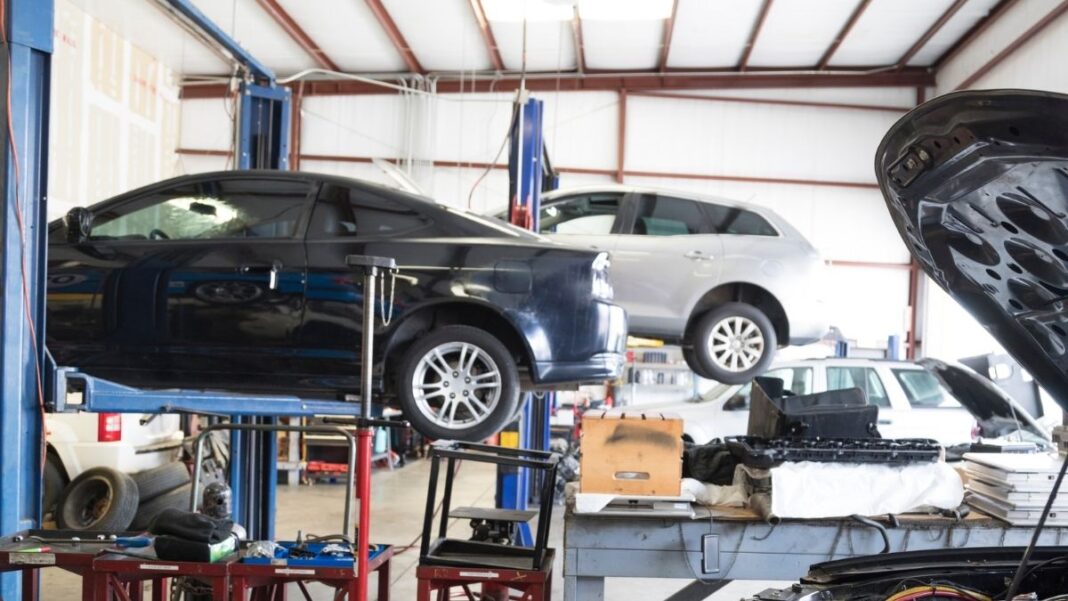 Taller mecánico reparando vehículos del parque automovilístico en España de distintas generaciones